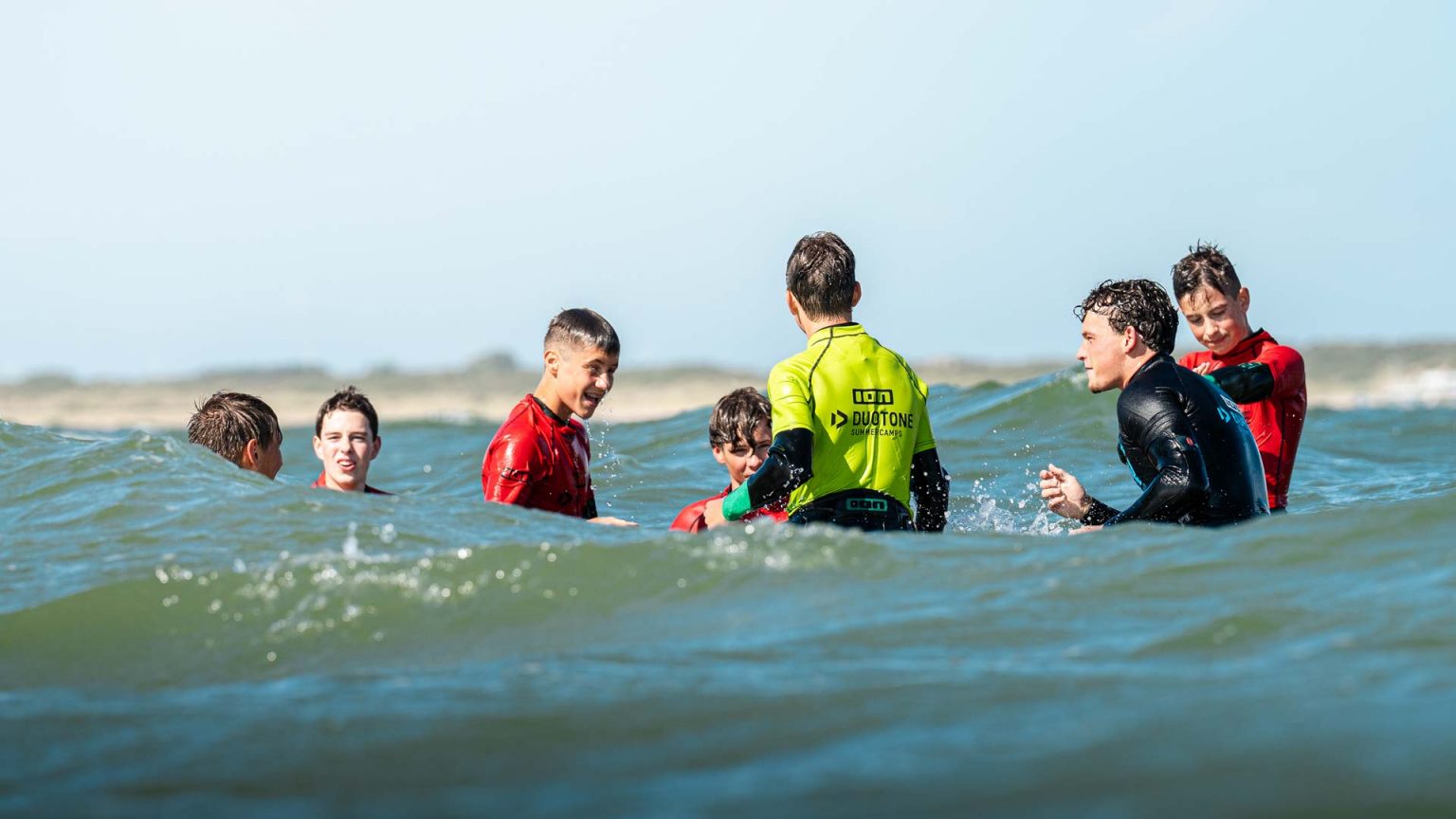 Kampkinderen samen lachend in het water aan de Brouwersdam