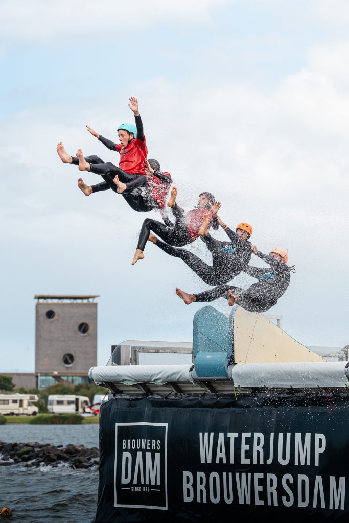 Kampkinderen springen van de waterjump